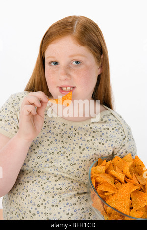 Overweight girl eating potato chips Stock Photo
