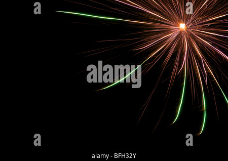Burst of  red and green fireworks on black sky in upper right corner Stock Photo