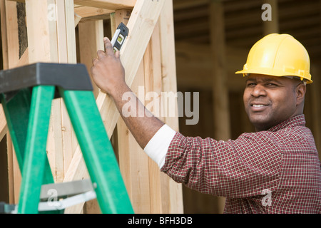 Construction worker using spirit level on building Stock Photo