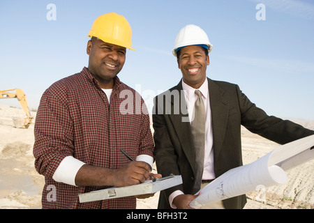 Surveyor and construction worker with blueprints, portrait Stock Photo