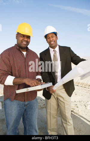 Surveyor and construction worker with blueprints, portrait Stock Photo