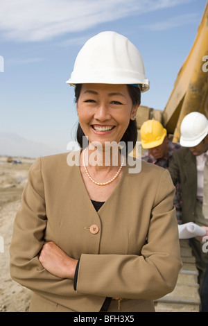 Female surveyor and construction workers on site, portrait Stock Photo