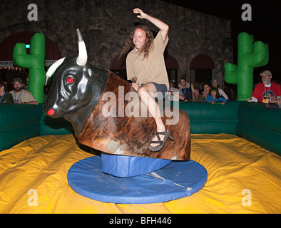 Riding a mechanical bull Texas USA Stock Photo