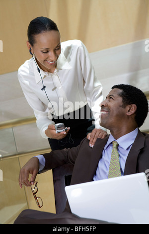 Two business colleagues using laptop and mobile phone Stock Photo