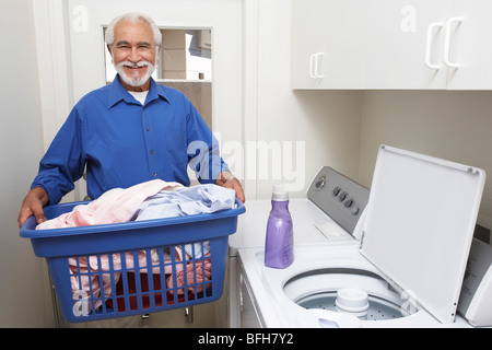 Elderly man with laundry basket Stock Photo