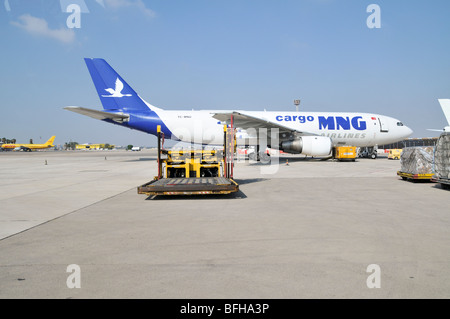 Israel, Ben-Gurion international Airport maintenance vehicle on the Tarmac. An MNG Cargo plane in the background Stock Photo