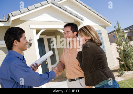 Architect with couple, shaking hands Stock Photo