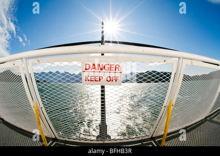 A sign on a ferry railing states 'Danger - Keep Off'. Stock Photo