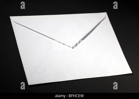 closed envelope with white spot light on black background Stock Photo