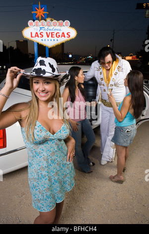 Portrait of young woman, two women with Elvis impersonator in background, Las Vegas, Nevada, USA Stock Photo