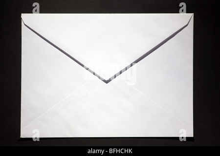 closed envelope with white spot light on black background Stock Photo