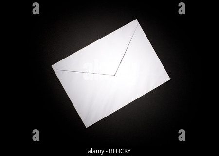 closed envelope with white spot light on black background Stock Photo