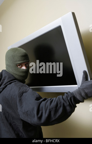 Thief stealing flat screen television Stock Photo
