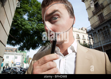 Man looking through magnifying glass Stock Photo