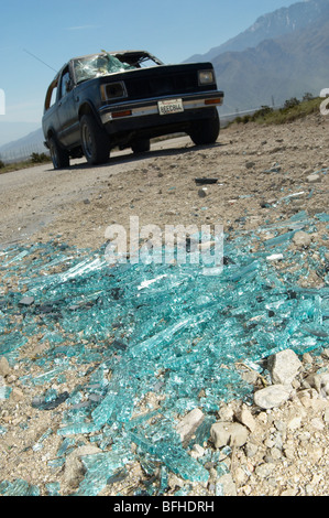 Close-up of broken windshield pieces on ground, truck in background Stock Photo