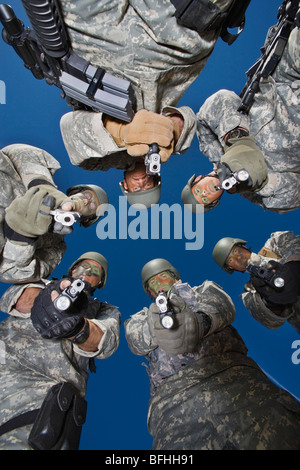 Low angle portrait of soldiers standing in circle, aiming Stock Photo