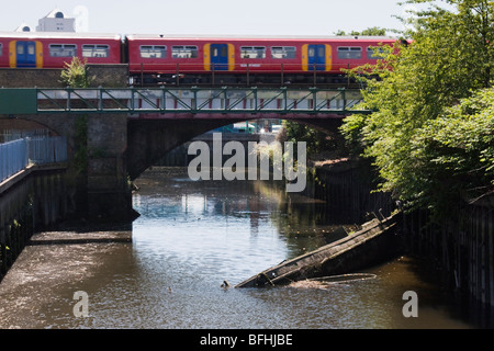 A train to Putney crosses the River Wandle in Wandsworth Stock Photo