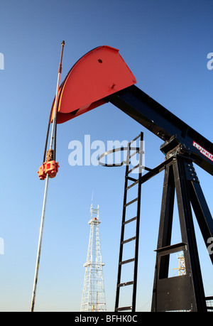 Pump jack with oil drilling rig in background at Canadian Petroleum Discover Museum in Devon, Alberta, Canada. Stock Photo