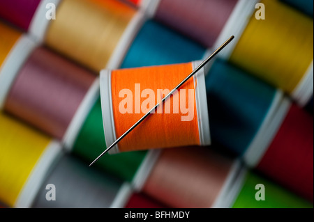 Bright colored spools of thread with sewing needle Stock Photo