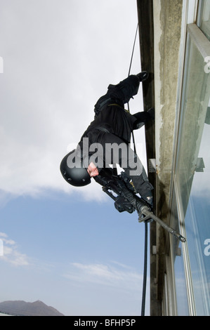 SWAT Team Officer Rappelling from Building Stock Photo