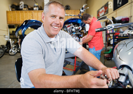 Mechanic Working on Motorcycle Stock Photo