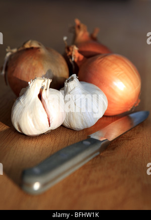 Onions and garlic bulbs with a kitchen knife Stock Photo