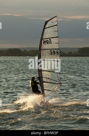 Windsurfers at sunset on Farmoor Reservoir, Oxfordshire, Uk Stock Photo