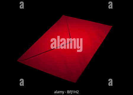 closed envelope with red spot light on black background Stock Photo