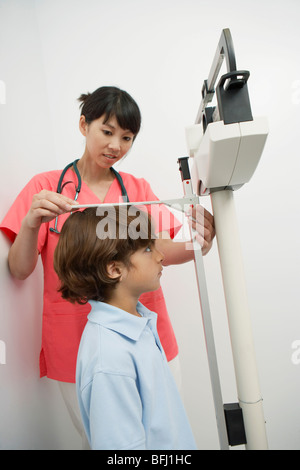 Female doctor measuring boy's height Stock Photo