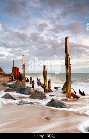 Derelict sea defences at first light at Happisburgh on the Norfolk Coast Stock Photo