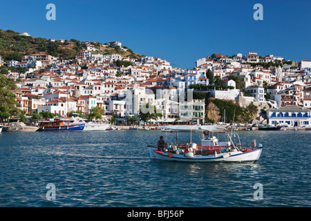 A fishing boat leaves harbour Skopelos Town Greek Islands Greece Stock Photo