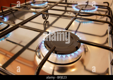 Modern gas stove with four burners alight. Foreground focus. Stock Photo