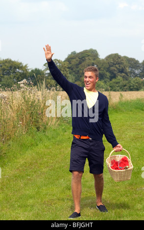Young man with picnic basket waving at someone Stock Photo