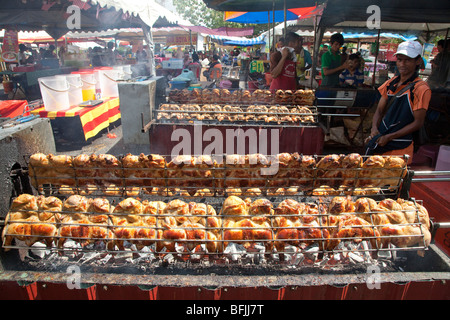 Malaysian market stall selling barbequed chicken using automated rotisserie, Malaysia Stock Photo