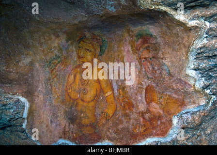 Ancient frescoes of maidens on cave wall at Sigiriya Rock Fortress, Sigiriya, Sri Lanka Stock Photo