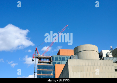 Crane on roof of new glass building under construction in Boston, Massachusetts USA Stock Photo