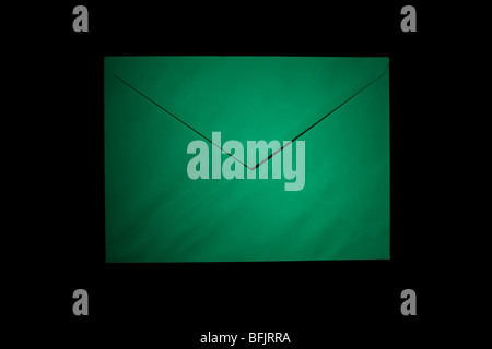 closed envelope with green spot light on black background Stock Photo