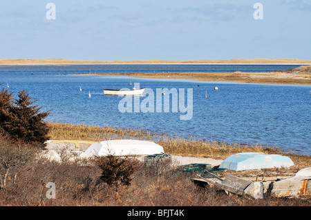 Scenic harbor in Chatham with rowboat on mooring and beached dinghies, Cape Cod, USA. Stock Photo