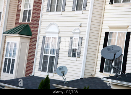 DirecTV satellite dishes in a suburban housing community.  Stock Photo