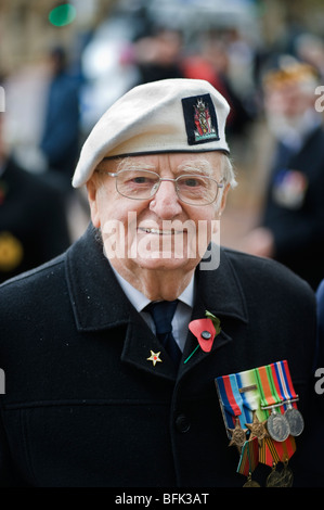 A war veteran and old soldier wearing a white beret and medals at the Remembrance Day Parade London. Stock Photo