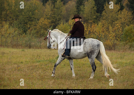 View of woman riding horse in rural setting Stock Photo