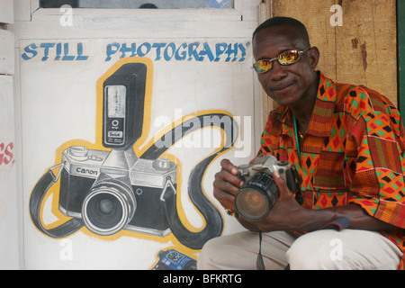 Kow Army Dauk aka Sanford poses for photographs outside his photography studio. Dixcove coastal town. Ghana. West Africa. Stock Photo