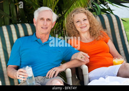 A senior man and woman couple enjoying drinks together on vacation after retirement Stock Photo