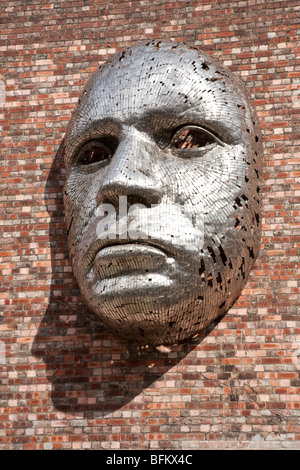 Metal face sculpture on outside wall of Lincoln City Drill Hall, by artist Rick Kirkby. Stock Photo