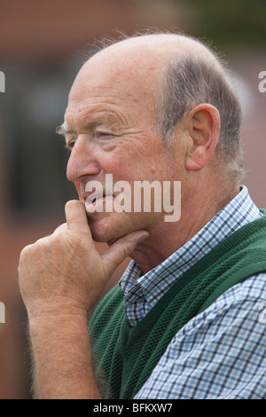 White mature man outside looking away from the camera and talking Stock Photo