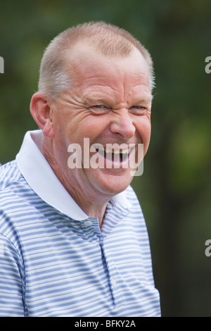 White middle aged man outside looking away from the camera and laughing Stock Photo
