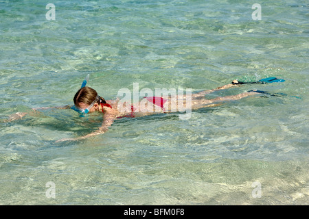 Young woman swimming in shallow waters, wearing snorkeling equipment, mask, snorkel and fins Stock Photo