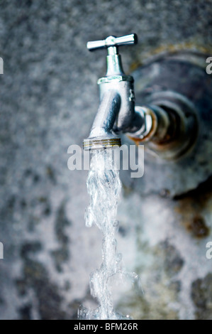 Closeup of water running from outdoor wall faucet Stock Photo