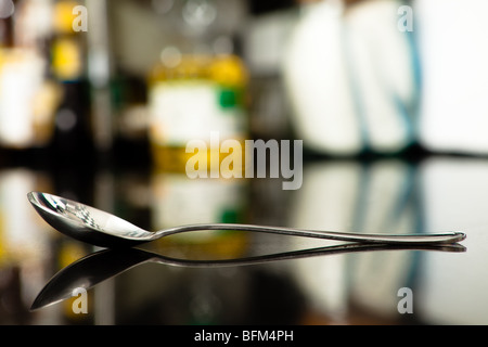 Old and Scratchy Spoon with its reflection isolated by shallow depth of field. Stock Photo