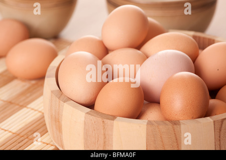 eggs in wooden bowl on table Stock Photo